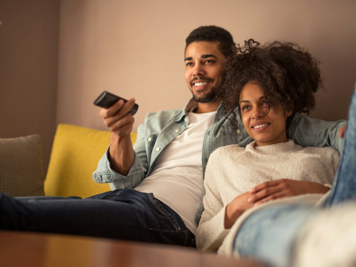 A couple choosing a movie to watch with a remote control